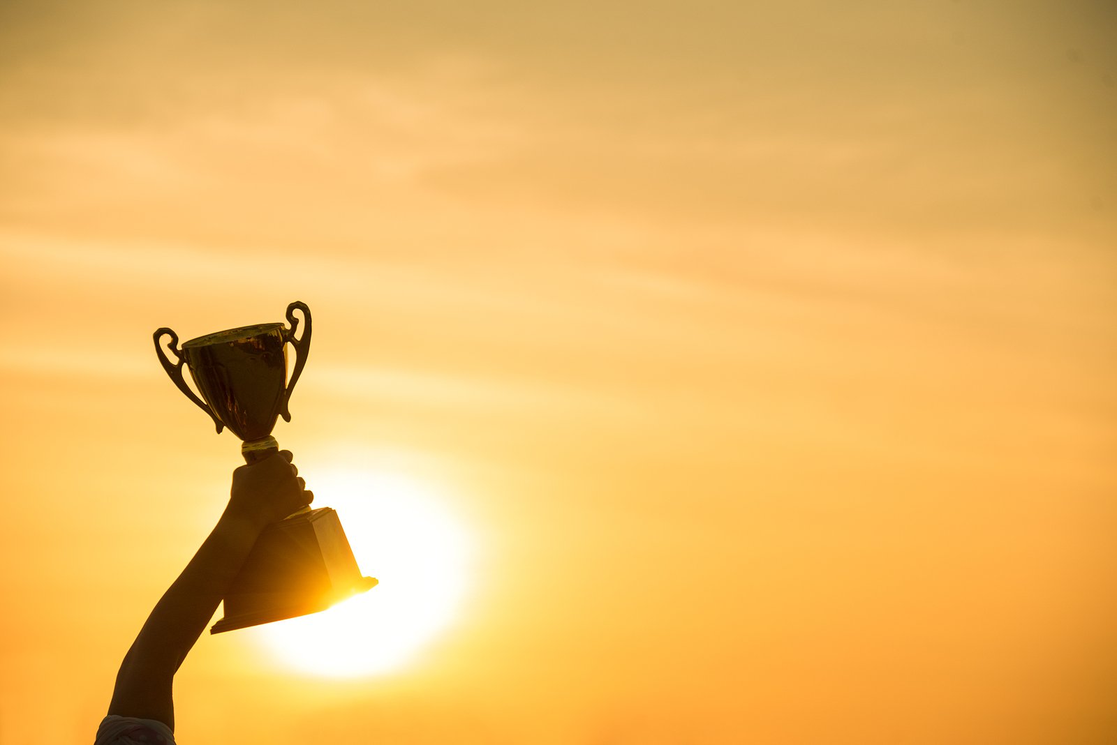 bigstock-Winner-Win-Holding-Golden-Cham-357321407
