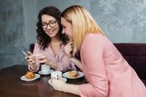 two-women-looking-on-smartphone