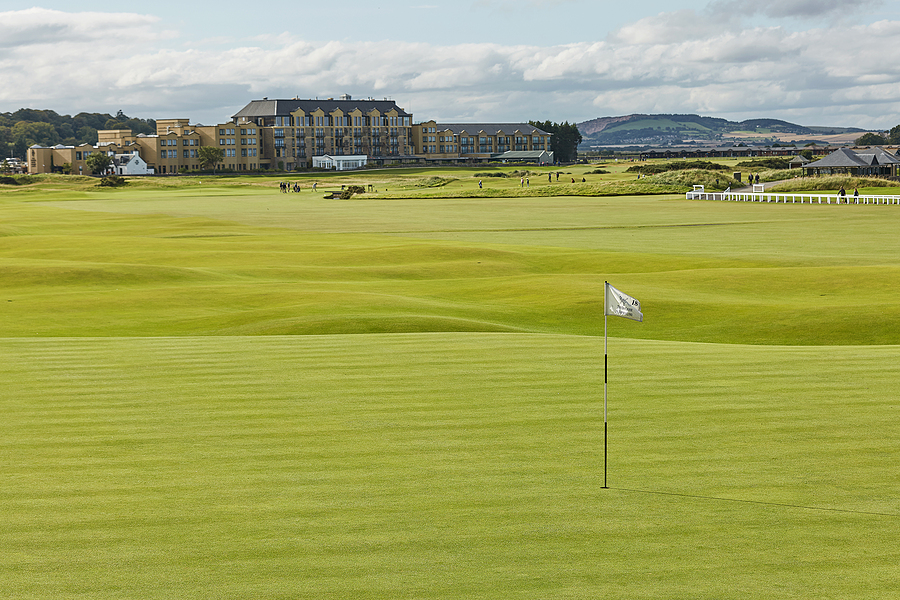 St. Andrews Clubhouse behind a vibrant green golf course in the foreground.